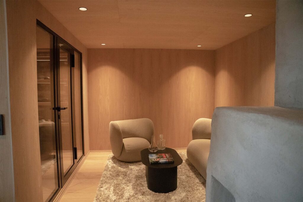 Moderne stue med elegante møbel- og interiørplater i tre, myke møbler og varmt, indirekte lys som skaper en avslappende atmosfære.